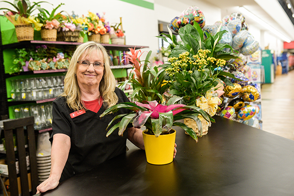 A Brookshire Brothers florist standing at a counter with a potted plant.