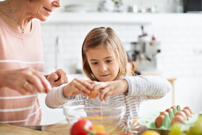 Small Girl Baking Cheesecake With Her Grandmother